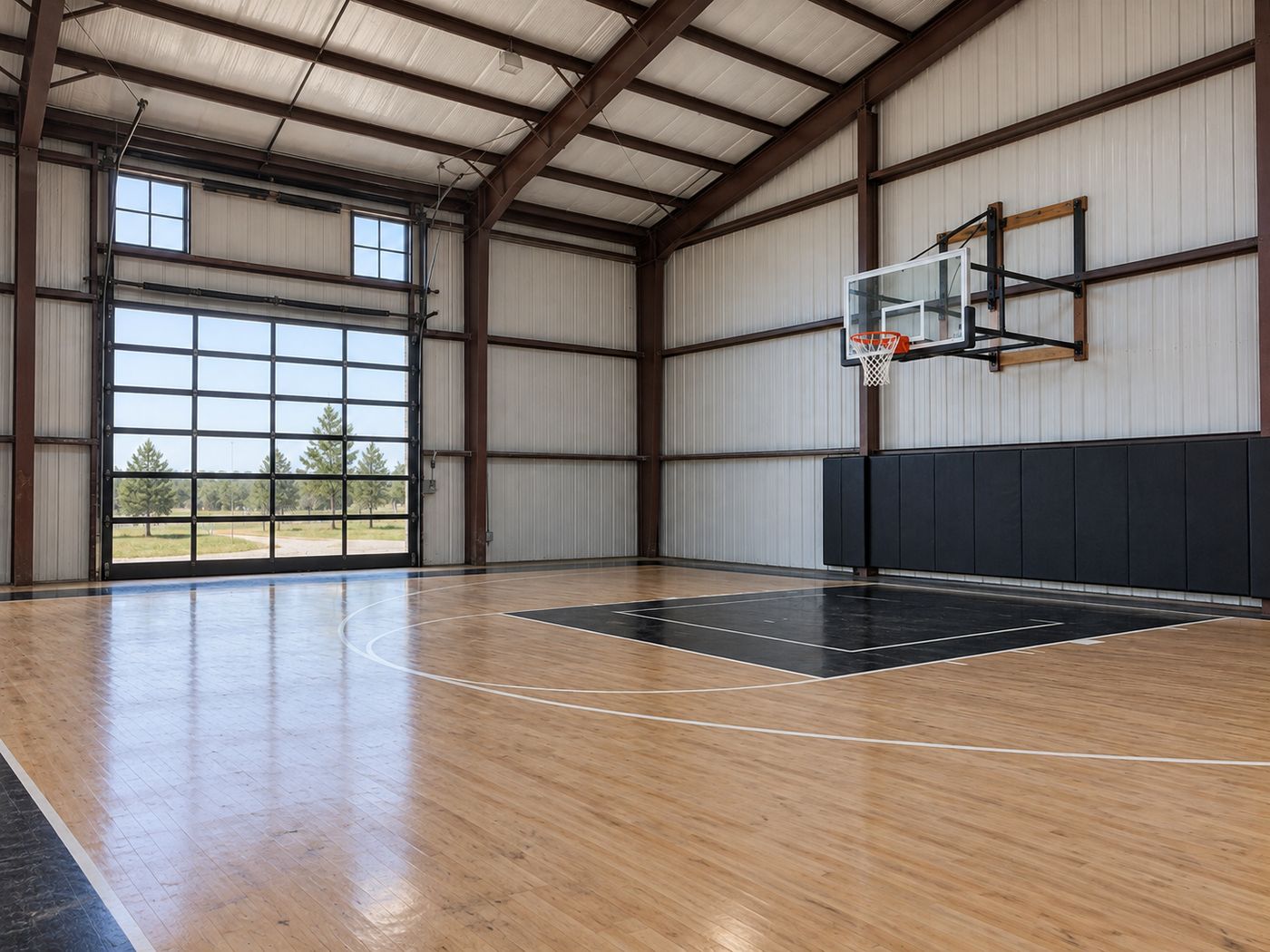 Indoor basketball court inside a barn-style building with hardwood-look surfacing